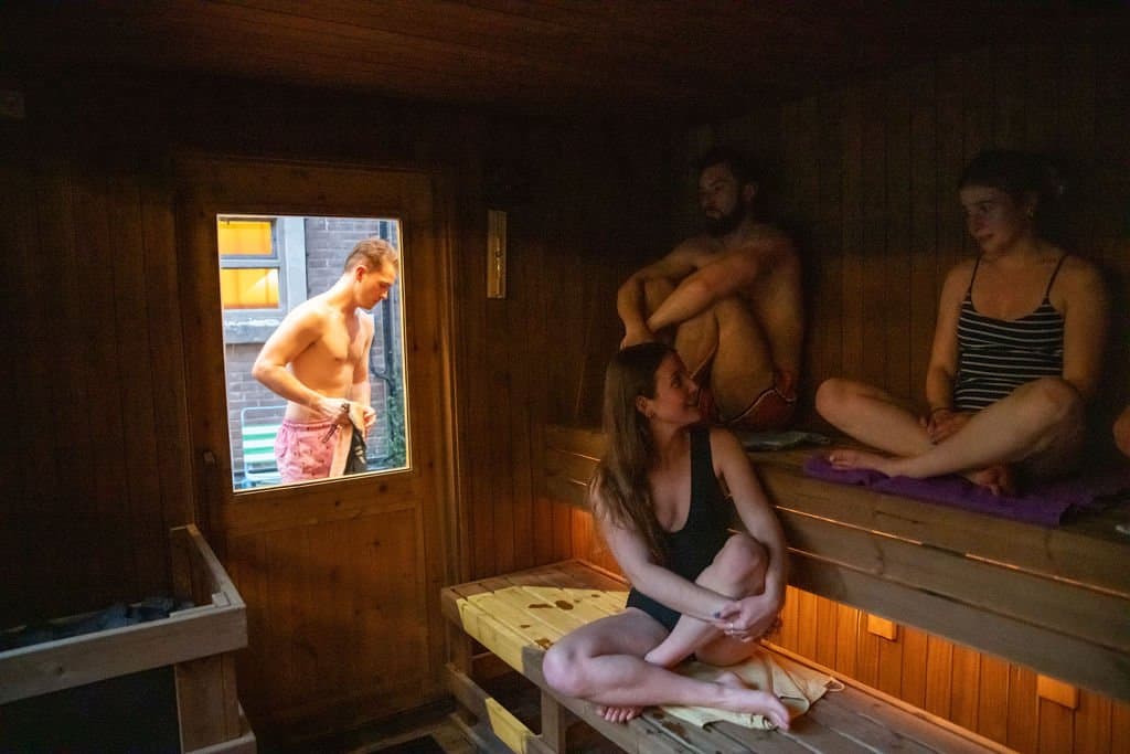 Inside the Bristol Community Sauna, with people relaxing on the timber benches