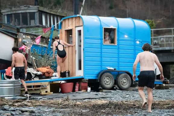 A mobile community sauna from the Community Sauna Network, beside an open-air cold plunge